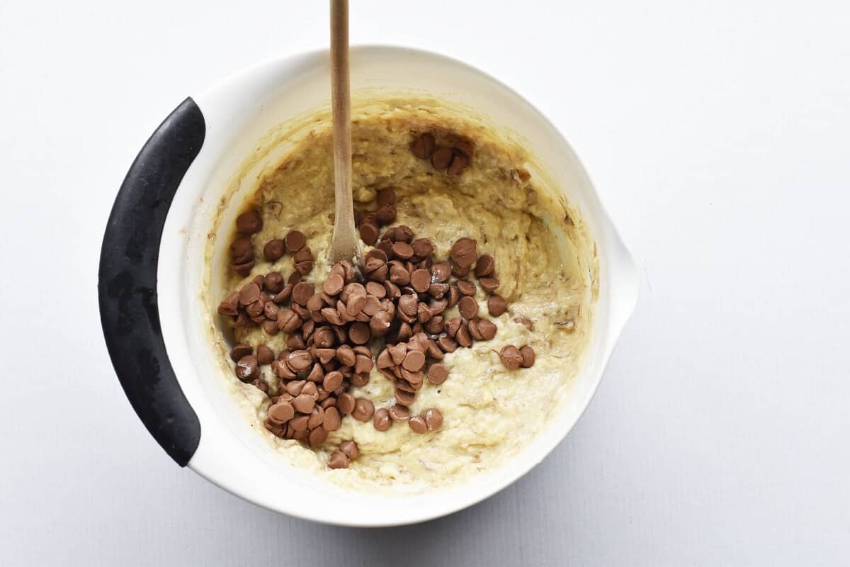 choc chip banana muffin mixture in a white bowl with black edge.