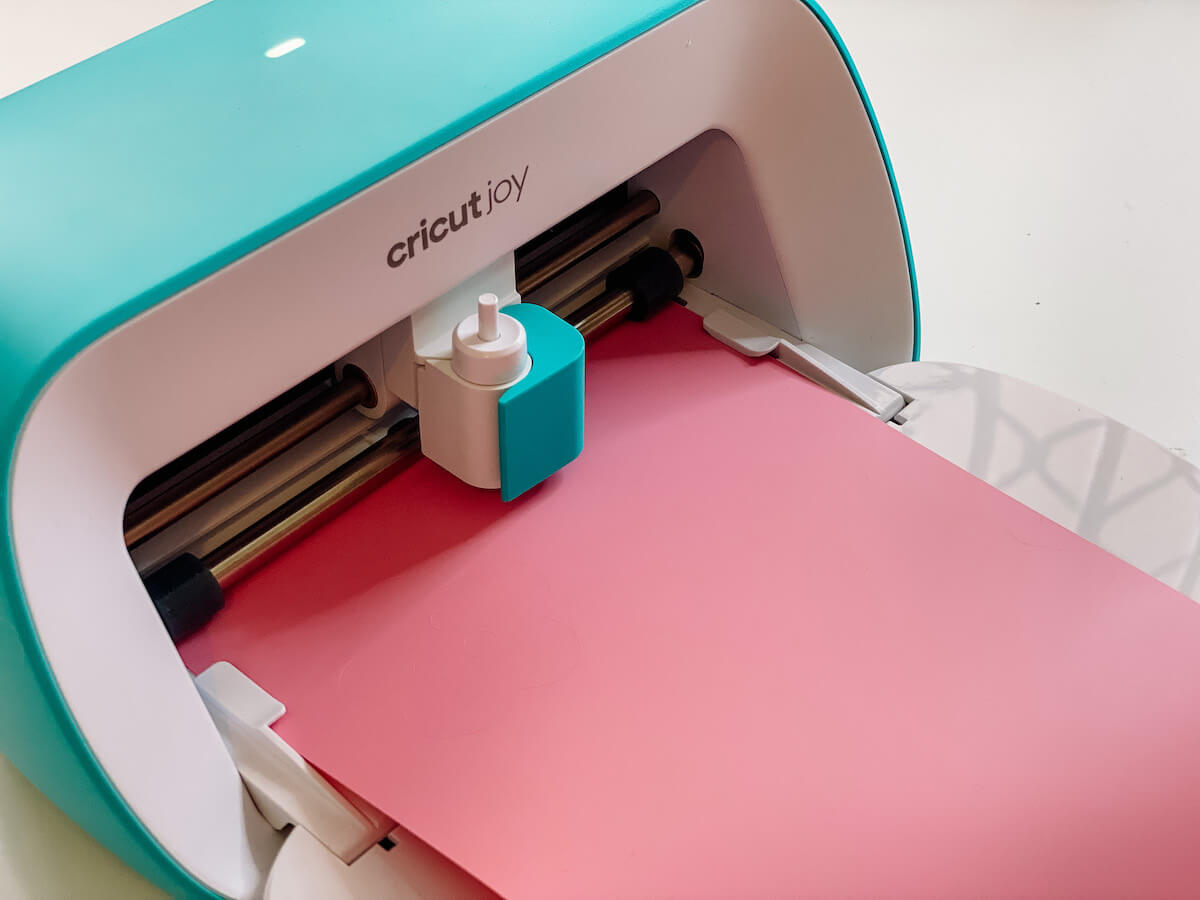 cricut joy machine with pink vinyl loaded in