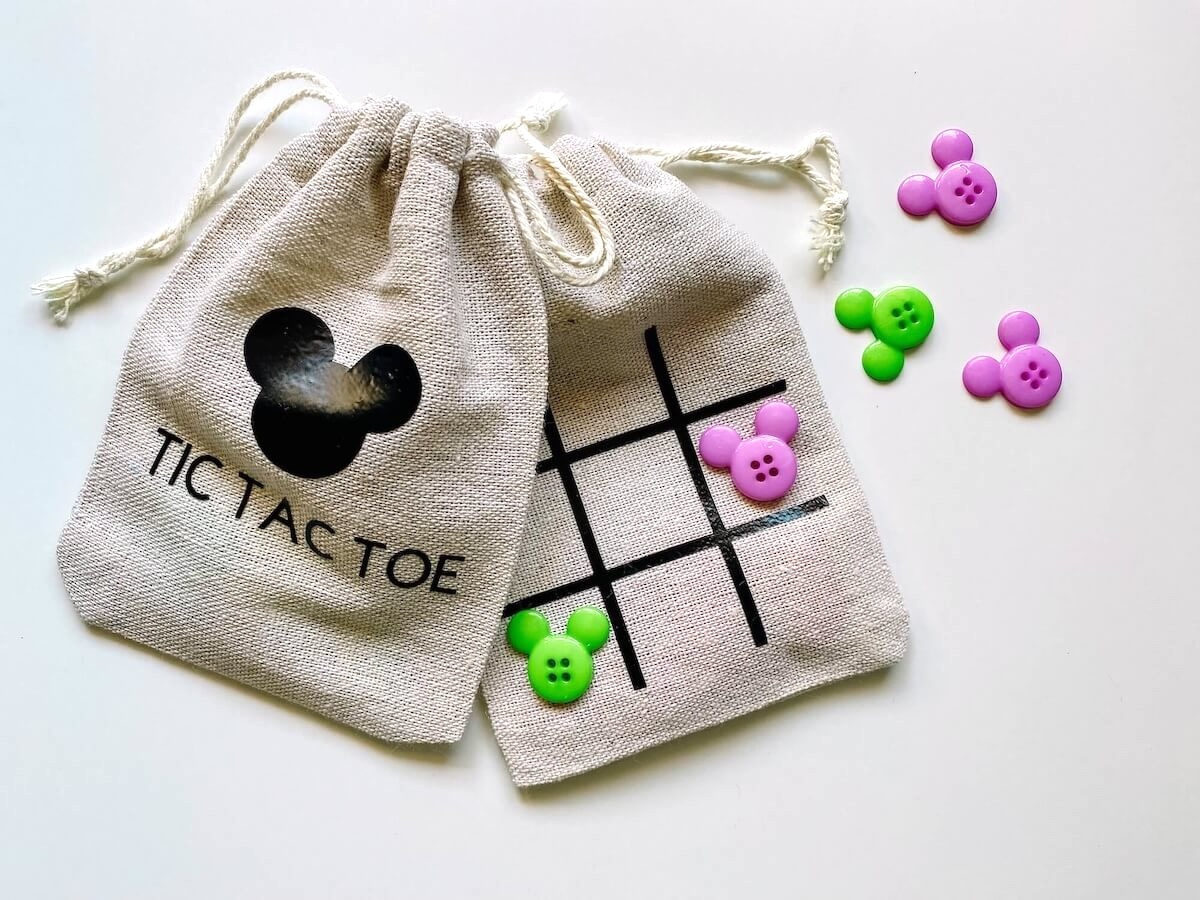 two tic tac toe bags with green and purple mickey mouse buttons.