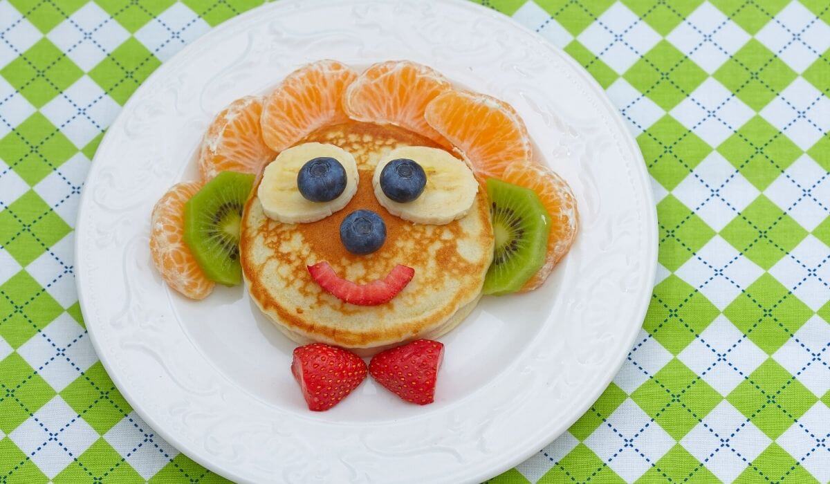 pikelet on a plate with fruit to look like a face