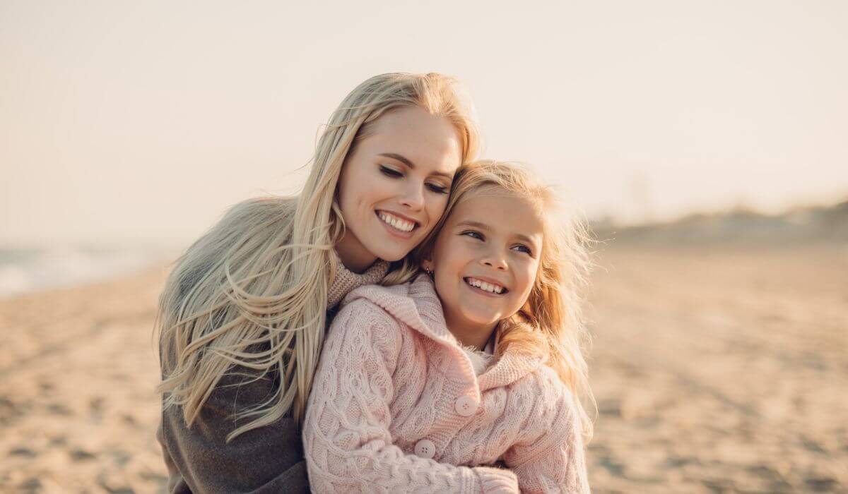 mother and daughter hugging at the beach