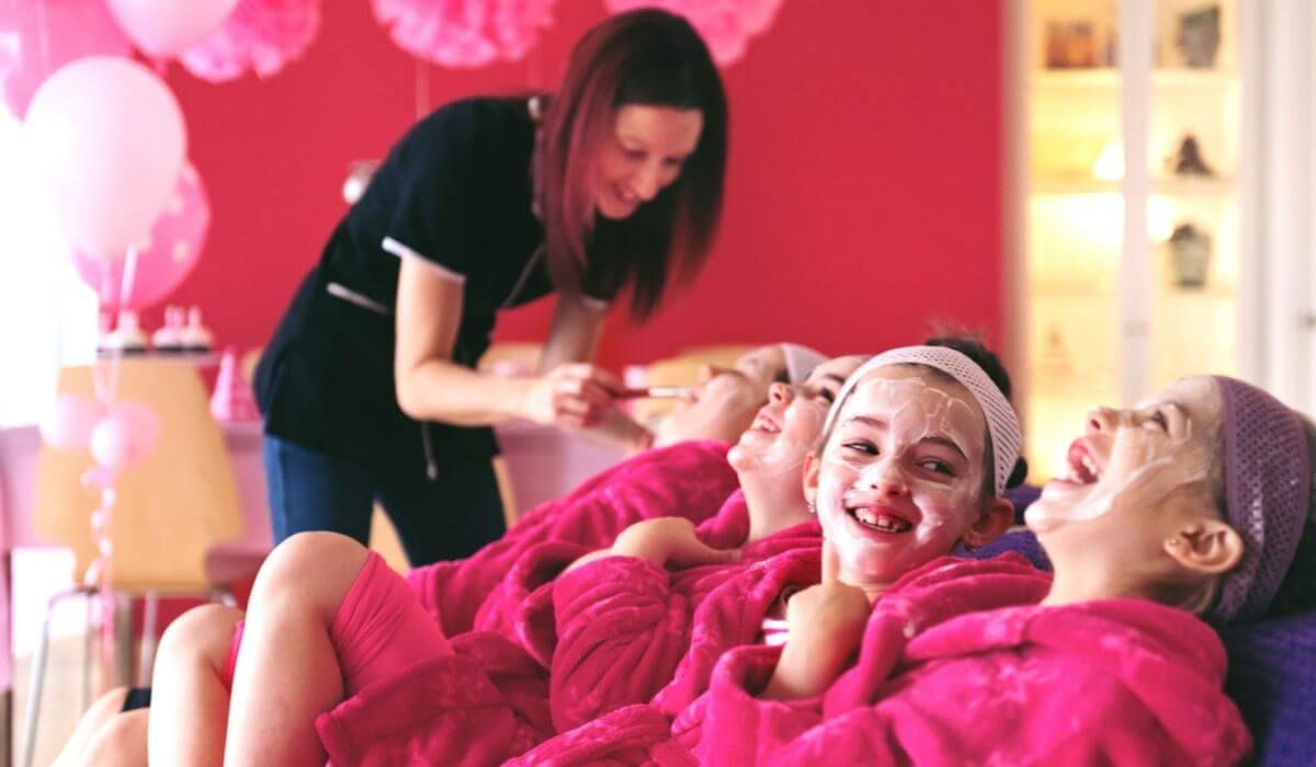 little girls in pink robes at pamper party with face mask on