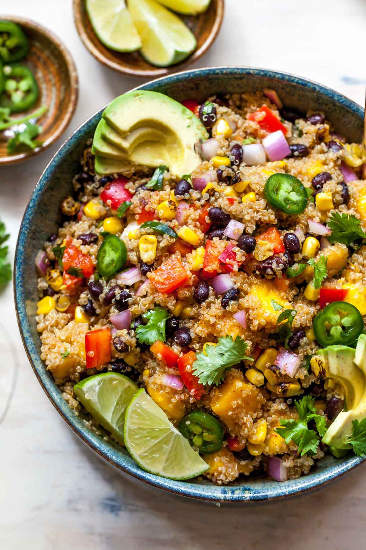 mango quinoa salad in dark blue bowl