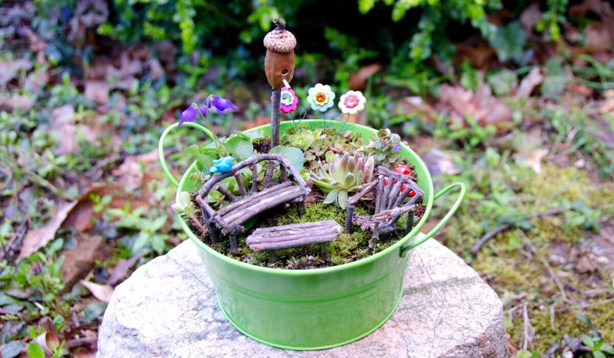 fairy garden in a green bucket