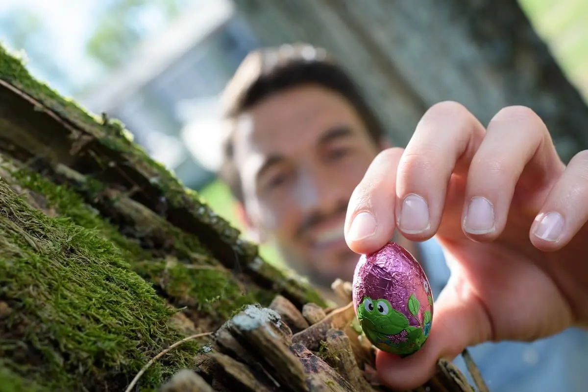 man hiding small chocolate easter egg