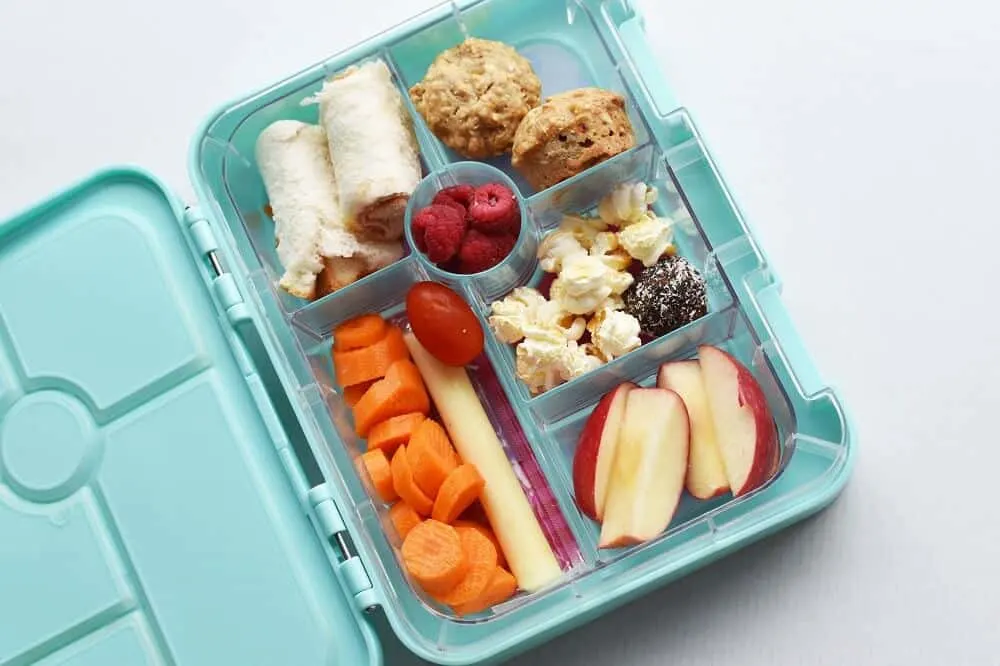 teal bento lunch box with a variety of healthy snacks