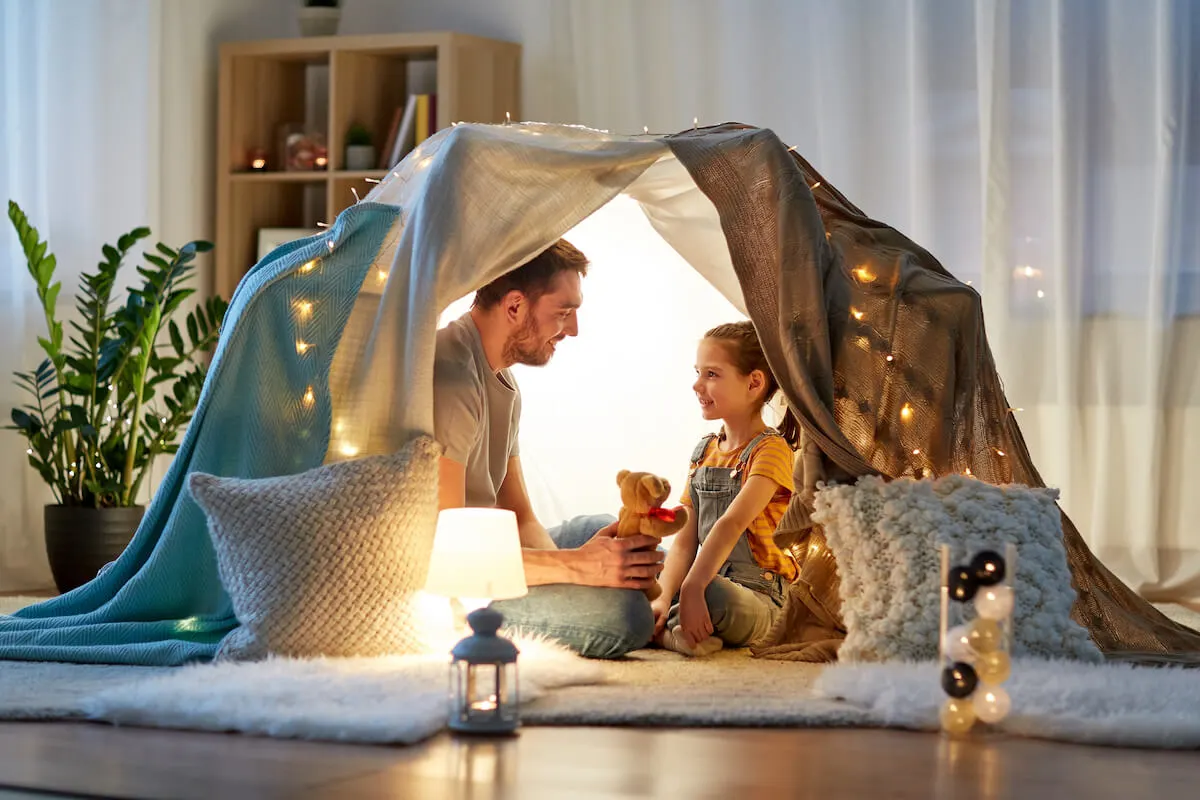 father and daughter inside a tent in their living room