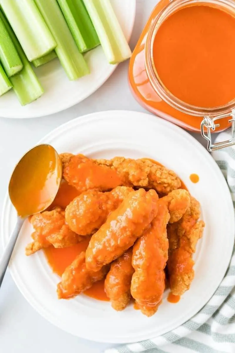 homemade buffalo sauce pouring over wings