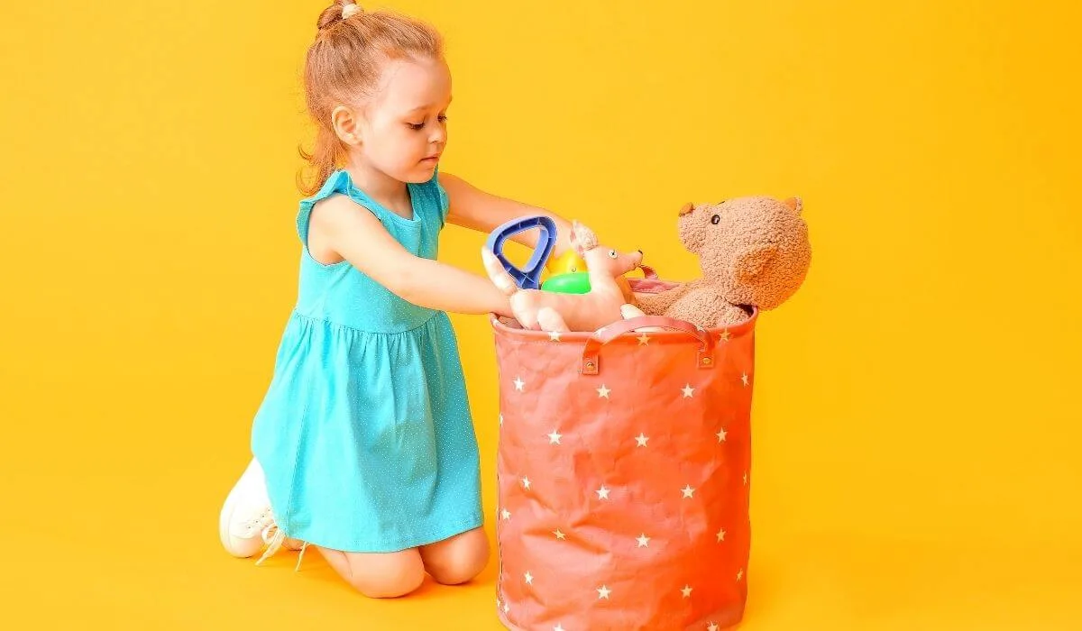 little girl putting toys in bag