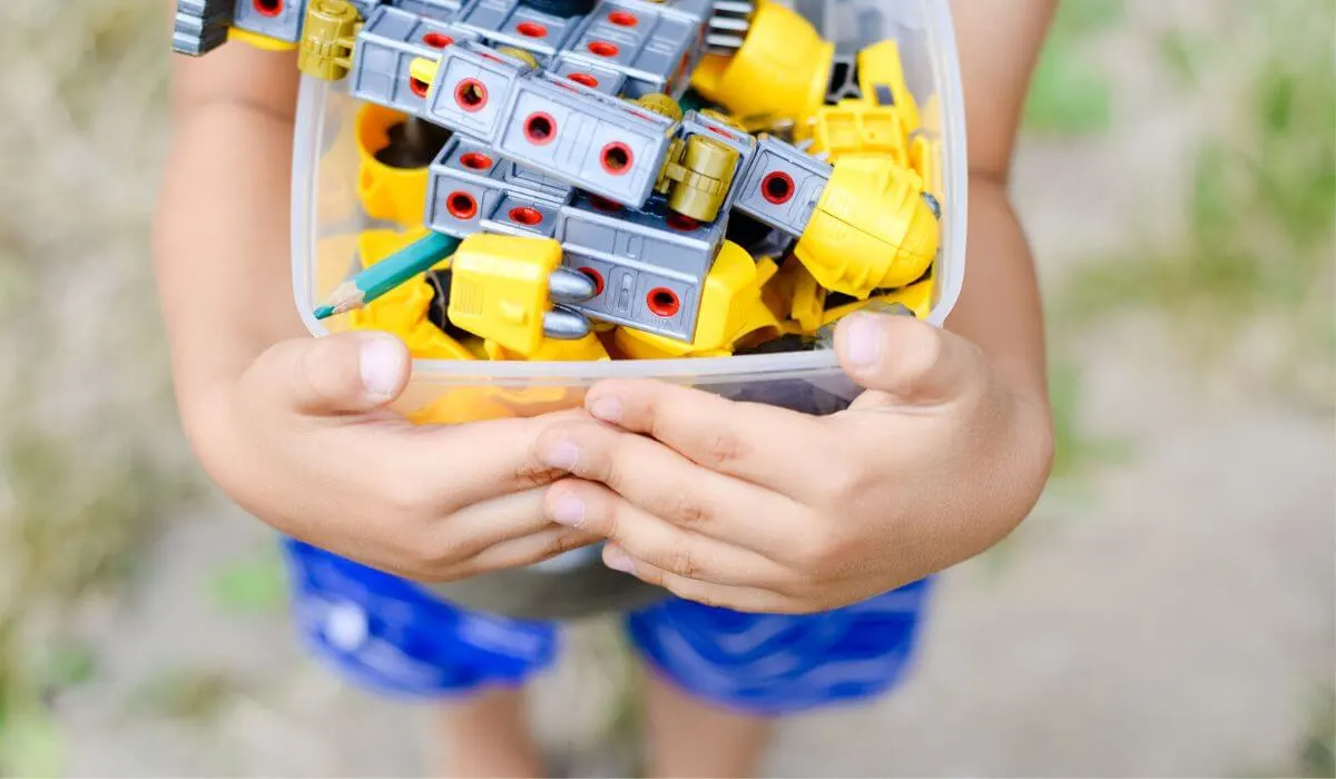 child holding tub of outdoor toys