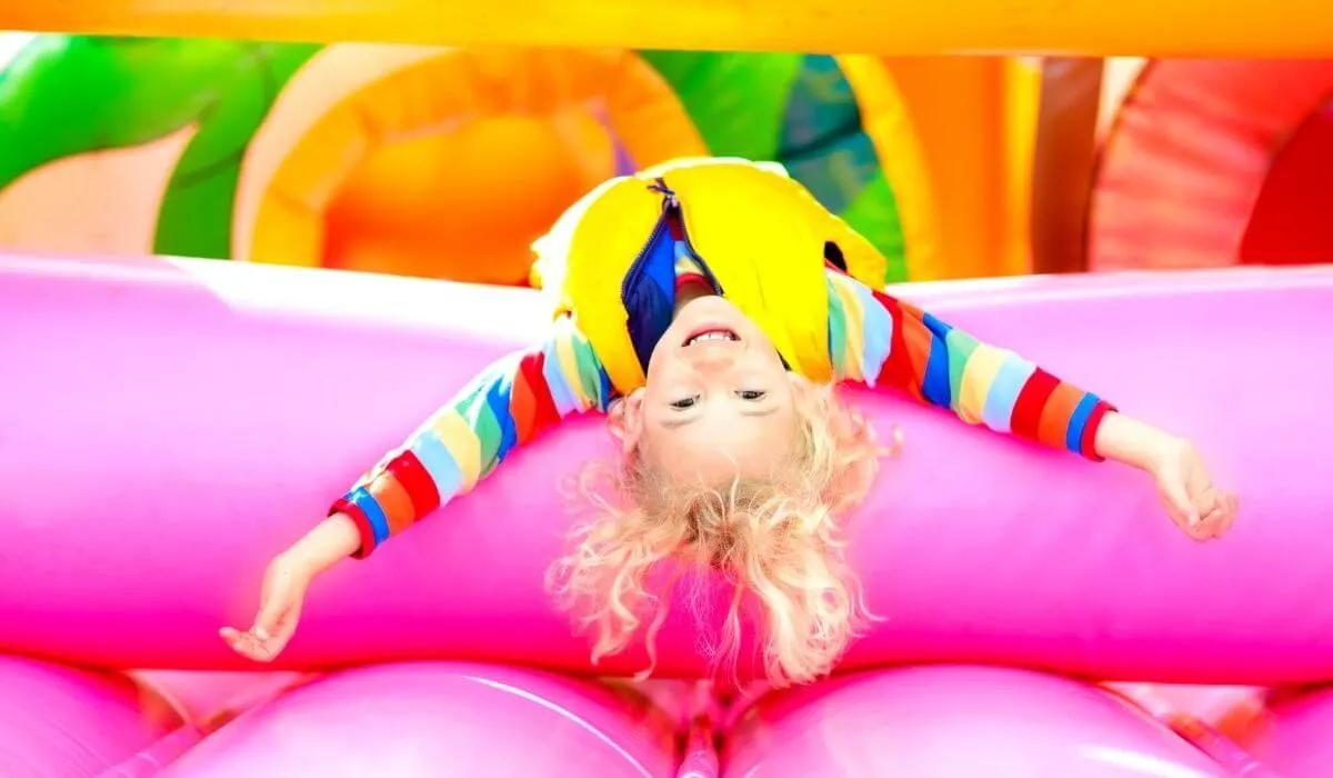 child upside down on a jumping castle